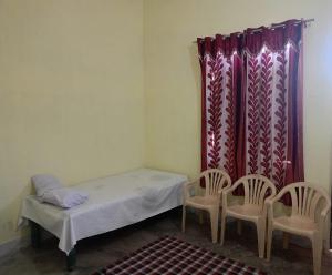 a small room with a bed and two chairs at Samriddhi Home stay in Prayagraj