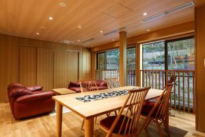 a living room with a table and a couch at Yuraku Kinosaki Spa & Gardens in Toyooka