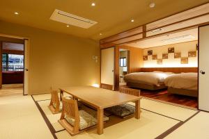 a dining room with a table and a bedroom at Yuraku Kinosaki Spa & Gardens in Toyooka +37 photos
