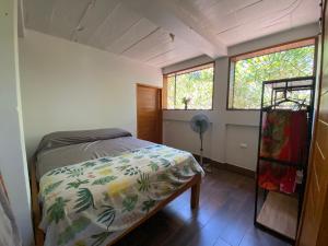 een slaapkamer met een bed en twee ramen bij Casa Mariposa Ometepe Suite in Santa Cruz