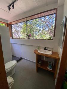een badkamer met een wastafel en een glas-in-loodraam bij Casa Mariposa Ometepe Suite in Santa Cruz