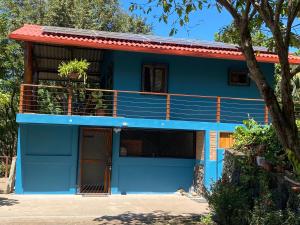 een blauw huis met een balkon bij Casa Mariposa Ometepe Suite in Santa Cruz