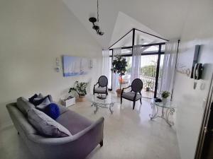 una sala de estar con un sofá y dos sillas en Paramount Views, en San Felipe de Puerto Plata