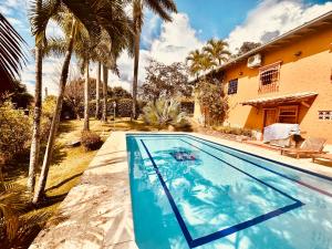 a swimming pool in front of a house with palm trees at Paradise San Jeronimo Parcelacion 6BR AC Pool in San Jerónimo