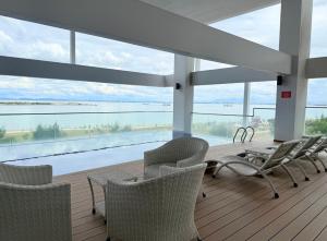 una terraza con sillas y una mesa con vistas al agua en Sunrise Gurney By IZ, en George Town