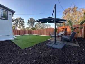 a backyard with an umbrella and a green lawn at Bungalow in San Diego