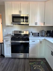 a kitchen with a stove and a microwave at Bungalow in San Diego