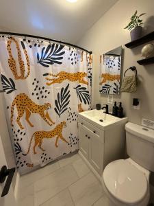 a bathroom with a cheetah shower curtain and a sink at Bungalow in San Diego +22 photos