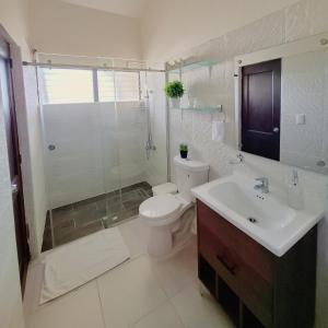 Un baño con inodoro, lavabo y ducha. en Paramount Views, en San Felipe de Puerto Plata 34 fotos más