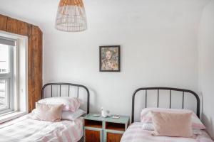 two beds sitting next to each other in a bedroom at Seaside home tucked one row back from Deal beach in Deal