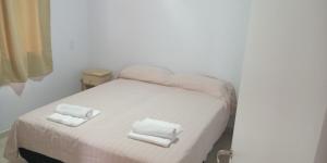 a small bedroom with a bed with towels on it at Cabañas Kaldak in Lago Puelo