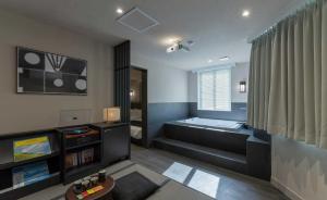 a living room with a tub and a television at Aank Ryokan Hotel Jeonju in Jeonju +172 photos