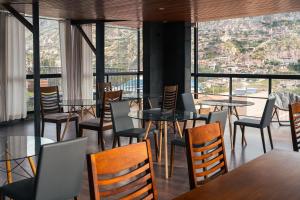 a restaurant with tables and chairs with a view at Hotel California Urubamba in Urubamba