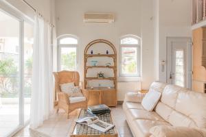 una sala de estar con un sofá y una silla en The Beach House, en Hersonissos