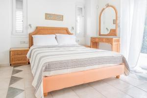 Un dormitorio con una cama grande y un espejo. en The Beach House, en Hersonissos