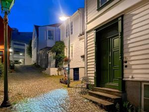 ein Gebäude mit einer grünen Tür in einer Kopfsteinpflasterstraße in der Unterkunft The Green 20 of Stavanger BnB in Stavanger