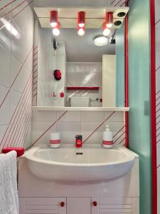 a bathroom with a white sink and red lights at Casa Cristallo in Breuil-Cervinia