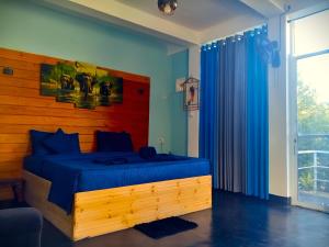 een slaapkamer met een blauw bed en een houten hoofdeinde bij Off grid Ella Homestay in Ella