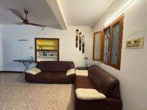 a living room with a brown couch and a table at Hostel Madras in Chennai