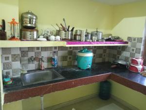 a kitchen counter with a sink and some pots and pans at Nandishwar Homestay in Varanasi