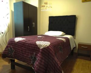 a bedroom with a bed with a purple blanket at Hotel San Miguel in San Miguel