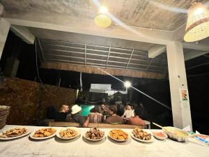 a table with several plates of food on it at Tata Surf Hostel in Kuta Lombok