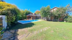 a backyard with a swimming pool and a house at La Quinta Rosefe in Luján