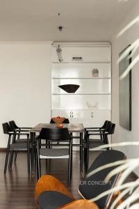 a dining room with black chairs and a table at CR Concept Serviced Apartment - Vinhomes and Landmark 81 in Ho Chi Minh City