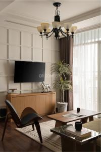 a living room with a table and a tv at CR Concept Serviced Apartment - Vinhomes and Landmark 81 in Ho Chi Minh City