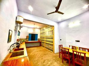 a dining room with a table and a ceiling fan at Pali Homestay Lansdowne Not Luxury but Stay with Legacy in Lansdowne