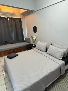 a bedroom with a large white bed and a window at Sea view homestay in Port Dickson