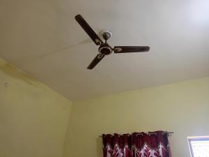 a ceiling fan in a room with a curtain at Samriddhi Home stay in Prayagraj