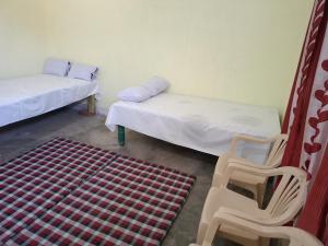 a room with two beds and a chair and a rug at Samriddhi Home stay in Prayagraj