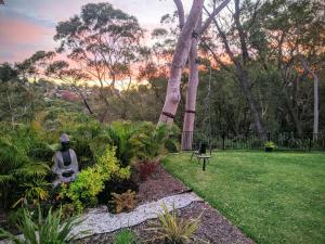 a garden with a bench in the grass at Beautiful Bush & Yoga Retreat Guest Favourite 6 Stars in Engadine
