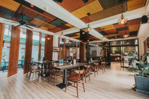 a restaurant with wooden tables and chairs and windows at SureStay Plus Hotel by Best Western AC LUXE Angeles City in Angeles