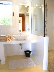 W białej łazience znajduje się umywalka i lustro. w obiekcie Luna&Limoni Country w mieście Muravera