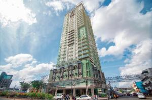 a tall building with people standing in front of it at 1517 Deluxe Room at Sunvida Tower in Cebu City