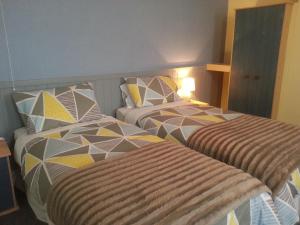 two beds in a hotel room with at Melbourne Guest House in Rhyl