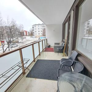 a balcony with a table and chairs and a window at Spacious Northern City Apartment in Rovaniemi