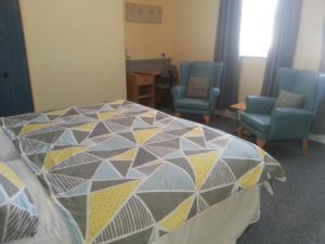 a room with a bed with chairs and a table at Melbourne Guest House in Rhyl