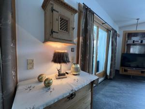 Camera con tavolo, lampada e TV di Heimatliebe Comfortable holiday residence a Ramsau