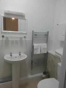 a white bathroom with a sink and a toilet at Melbourne Guest House in Rhyl
