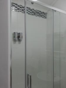 a shower with a glass door in a bathroom at Melbourne Guest House in Rhyl