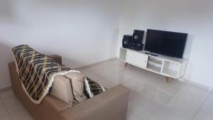a living room with a couch and a flat screen tv at Recanto do Ze Bonito in Conde