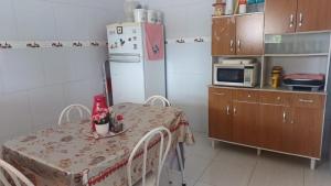 a small kitchen with a table and a refrigerator at Recanto do Ze Bonito in Conde