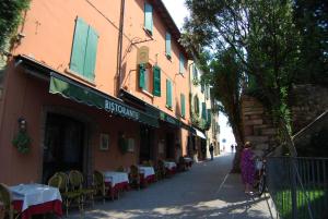 an empty street with tables and chairs on a building at Appartamenti Corneliani in Sirmione