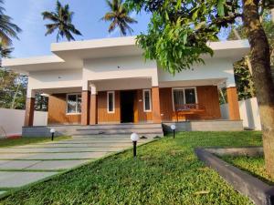 una casa con un prato verde davanti di Captain's Castle a Pallipuram