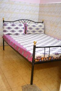 a bed with a black frame with flowers on it at S M Residency in Mayiladuthurai