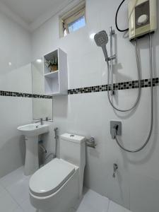 a white bathroom with a toilet and a shower at Sea View in Meedhoo