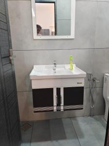un bagno con un lavandino bianco e uno specchio di Captain's Castle a Pallipuram